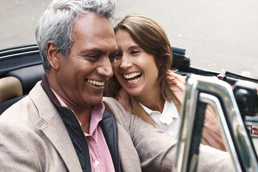 Confidently smiling couple driving in a convertible