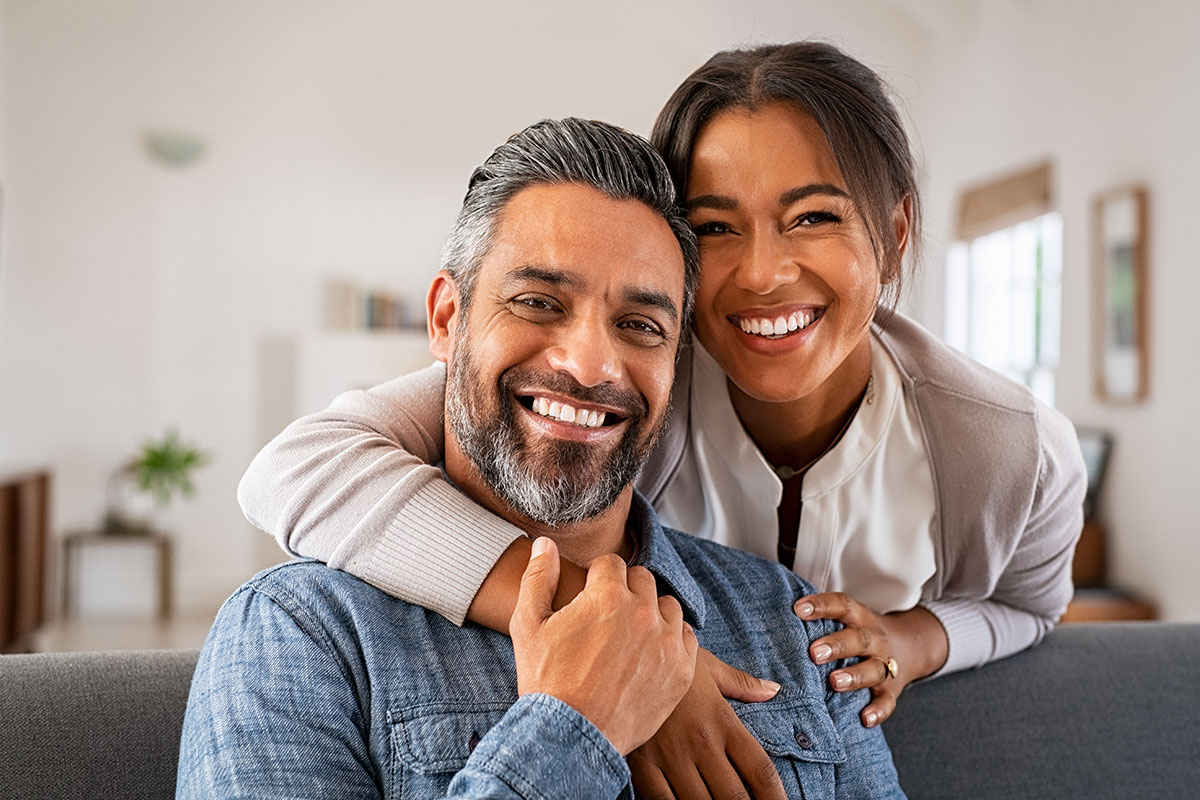 Couple in their 40's happily smiling at home